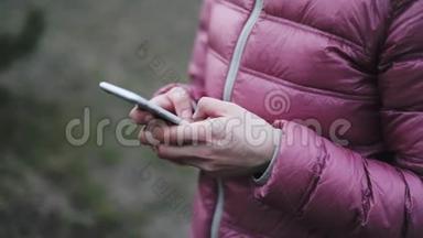 手拿着粉红色夹克，手拿着手机
